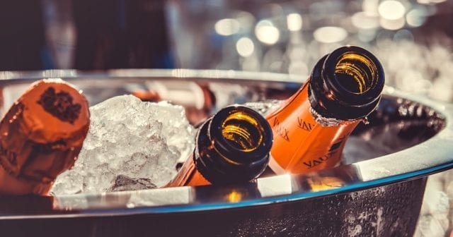 champagne bottles on ice at a new year's eve party where people are celebrating the new year safely