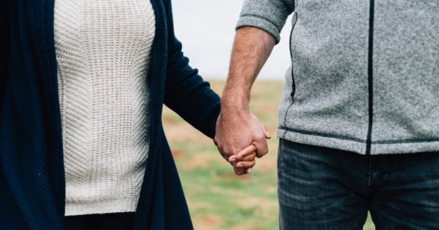 a couple discussing the gift of life insurance on valentine's day while holding hands outdoors