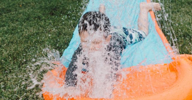 a child playing on a slip and slide