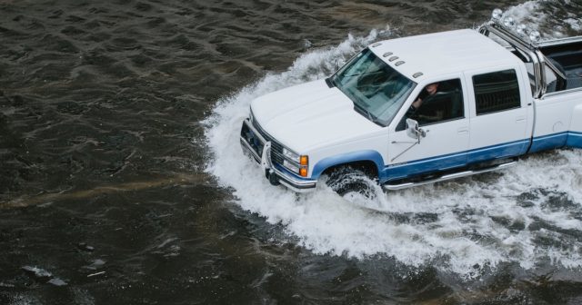 a man driving through a flood who understands what flood zones are and why they matter