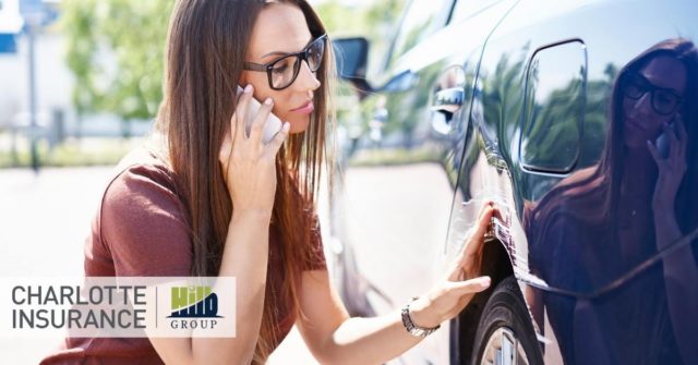 a woman inspecting her damaged car while on the phone with her insurance agent discussing her options regarding uninsured and underinsured motorist coverages