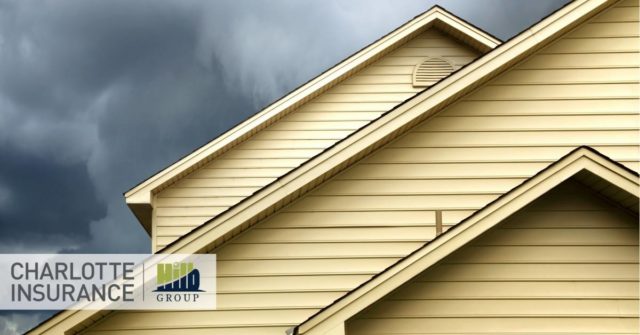 a close up of a home's roof with storm clouds in the background