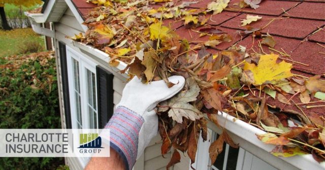 a person cleaning their gutters as part of their fall maintenance checklist
