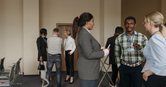 a condo / HOA association meeting about insurance. httpswww.pexels.comphotogroup-of-people-standing-in-the-room-8761634