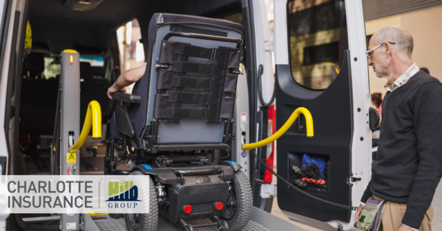 A NEMT driver securing a passenger in a wheelchair safely into a van for transport