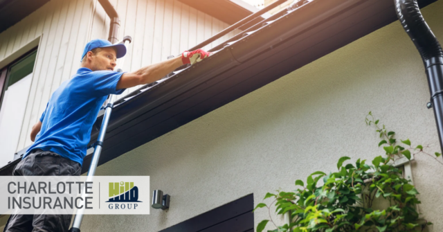 a person on a ladder cleaning the gutters as part of their HOA's fall maintenance